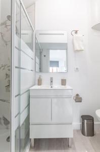 een witte badkamer met een wastafel en een spiegel bij Studio de luxo no Porto - T0 in Porto