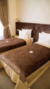 2 camas en una habitación de hotel con 2 camas en Boutique Spa Casino Hotel Lybid Plaza, en Khmelʼnytsʼkyy
