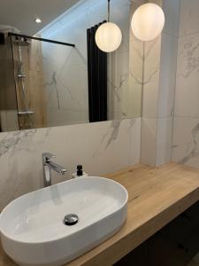 a bathroom with a white sink and a mirror at Apartamenty Beauty & SPA in Ełk