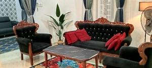 een woonkamer met een bank en 2 stoelen bij FH Homestay 4BR in Wakaf Baharu