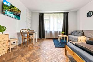 een woonkamer met een bank en een tafel bij Cosy Studio 10 min Center in Bratislava