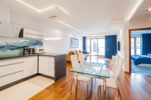 a kitchen and living room with a glass table and chairs at Drim Apartaments in Gdańsk