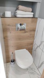 La salle de bains est pourvue de toilettes blanches et de serviettes. dans l'établissement Studio27, à Wrocław