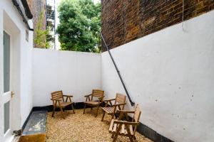 a group of chairs sitting next to a wall at Luxury 2 Bedroom apartment in King's Cross in London