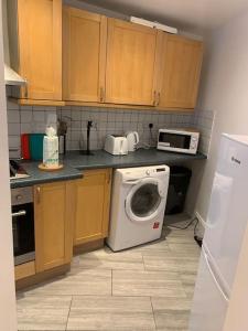 a kitchen with a washing machine and a microwave at Luxury 2 Bedroom apartment in King's Cross in London
