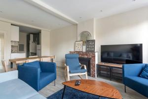 un salon avec des chaises bleues et une cheminée dans l'établissement Hamac Suites - Suite Arloing - 6 people, à Lyon