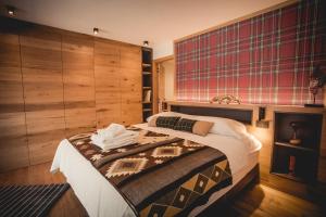 1 dormitorio con 1 cama grande y paredes de madera en Chalet Snostorm, en Crépin
