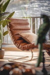 a wicker chair with a pillow on a porch at Chalet Snostorm in Crépin