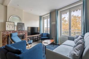 un salon avec des chaises bleues et une cheminée dans l'établissement Hamac Suites - Suite Arloing - 6 people, à Lyon