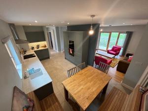 a kitchen and living room with a wooden table and a dining room at Ashwood House at Thoulstone Park in Corsley