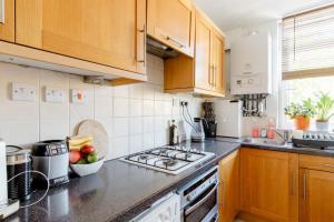 a kitchen with a stove and a bowl of fruit on the counter at Central London Stylish Flat with Terrace in London