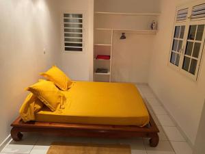 Rivière-SaléeにあるJolie villa F4 vue merの大きな黄色のベッドが備わる客室です。