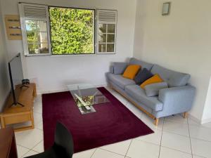 ein Wohnzimmer mit einem Sofa und einem Tisch in der Unterkunft Jolie villa F4 vue mer in Rivière-Salée
