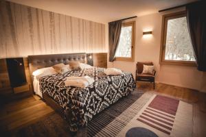 a bedroom with a large bed and a chair at Chalet Snostorm in Crépin