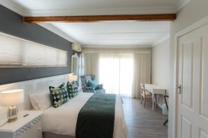 a hotel room with a bed and a desk and a window at Blue View B&B in East London +70 photos