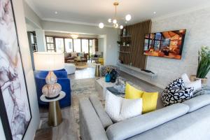 a living room with a gray couch and yellow pillows at Blue View B&B in East London