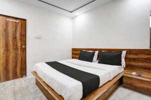 een slaapkamer met een groot bed met een houten hoofdeinde bij Hotel Apollo in Ahmedabad