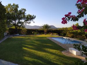 a garden with a pool and trees and flowers at Villa Paradisos Archangelos in Archangelos