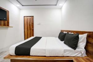 a bedroom with a large bed with black and white pillows at Hotel Apollo in Ahmedabad