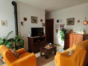 a living room with two orange chairs and a television at La Casa di LiLi in Pontassieve