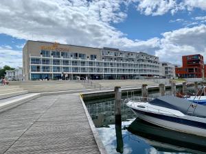 a building with a boat in the water next to a dock at SlowDown Travemünde in Travemünde