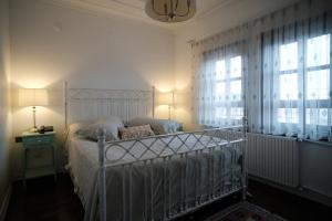 a bedroom with a white bed and a window at MECİT KAPTAN KONAĞI in Kastamonu