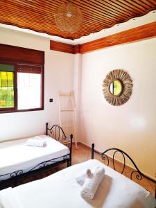 a room with two beds and a mirror on the wall at Olympe Surf & Yoga in Tamraght Ouzdar