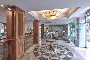 a large lobby with a table in a room at Hotel Firenze in Serra Negra