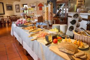 długi stół z bufetem z jedzeniem na nim w obiekcie Hotel Zì Martino w mieście Castagneto Carducci