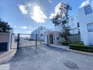 ein Tor auf einem Parkplatz neben einigen Gebäuden in der Unterkunft Espacio Yuca con Rooftop Privado, Alberca, Parking, Tren Maya cercano in Playa del Carmen