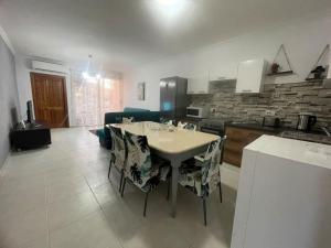 een keuken en een woonkamer met een tafel en stoelen bij Mellieha Apartment in Mellieħa