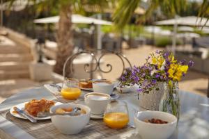 a table topped with plates of breakfast food and orange juice at Château St Pierre de Serjac in Puissalicon