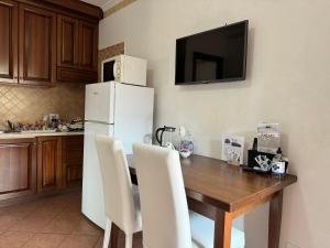 a kitchen with a wooden table and a white refrigerator at EURO HOUSE INN airport in Fiumicino