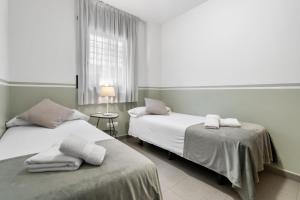 a bedroom with two beds with towels on them at Sensation Authentic Gràcia in Barcelona