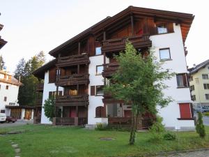 ein Gebäude mit Balkonen und einem Baum davor in der Unterkunft Seebach B1 in Arosa