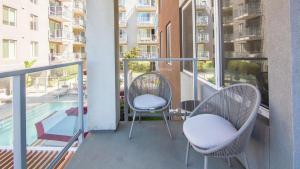 einen Balkon mit 2 Stühlen und einem Pool in der Unterkunft Landing Modern Apartment with Amazing Amenities (ID2542X13) in San Diego