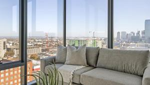 um sofá num quarto com janelas grandes em Landing - Modern Apartment with Amazing Amenities (ID1401X746) em Nashville