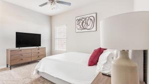 um quarto com uma cama e uma televisão de ecrã plano em Landing Modern Apartment with Amazing Amenities (ID7008X25) em Bentonville