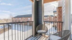 uma varanda com 2 cadeiras e uma grande janela em Landing Modern Apartment with Amazing Amenities (ID7008X25) em Bentonville