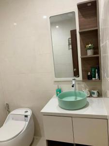 a bathroom with a sink and a toilet and a mirror at Nhung's House in Thôn Dương Phẩm