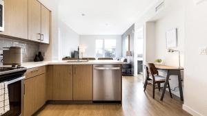 a kitchen with wooden cabinets and a table with a tableablish at Landing Modern Apartment with Amazing Amenities (ID7724X75) in South San Francisco