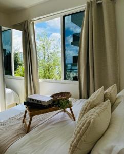 Un dormitorio con una cama con una mesa con libros. en Lazzlla beachside studio apartments en Hulhumale