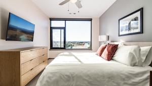 - une chambre avec un grand lit et une grande fenêtre dans l'établissement Landing Modern Apartment with Amazing Amenities (ID2723X7), à Denver