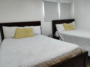sypialnia z 2 łóżkami z żółtymi i białymi poduszkami w obiekcie Vista marina Marbella w mieście Juan Pedro