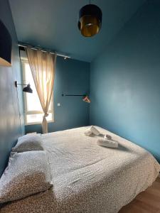 Un dormitorio con una cama blanca con una ventana. en .Le Perchoir., en Les Sables-dʼOlonne