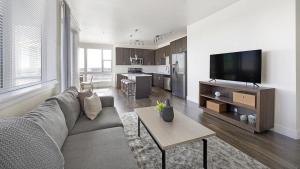 uma sala de estar com um sofá e uma mesa em Landing Modern Apartment with Amazing Amenities (ID9253X93) em Denver