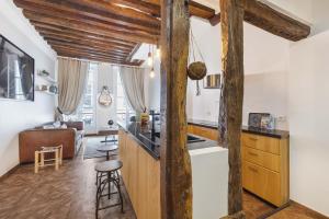 a kitchen and living room with wooden beams at Gentilhomme in Paris