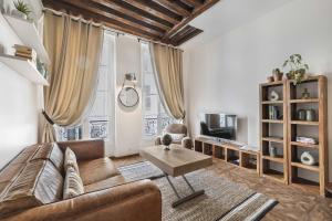 a living room with a couch and a table at Gentilhomme in Paris