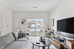 ein Wohnzimmer mit einem Sofa, einem TV und einem Tisch in der Unterkunft Landing Modern Apartment with Amazing Amenities (ID7435X07) in Omaha