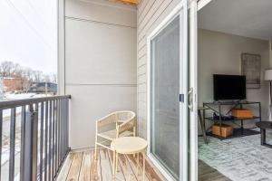 einen Balkon mit einem Stuhl und einem TV in der Unterkunft Landing Modern Apartment with Amazing Amenities (ID7435X07) in Omaha